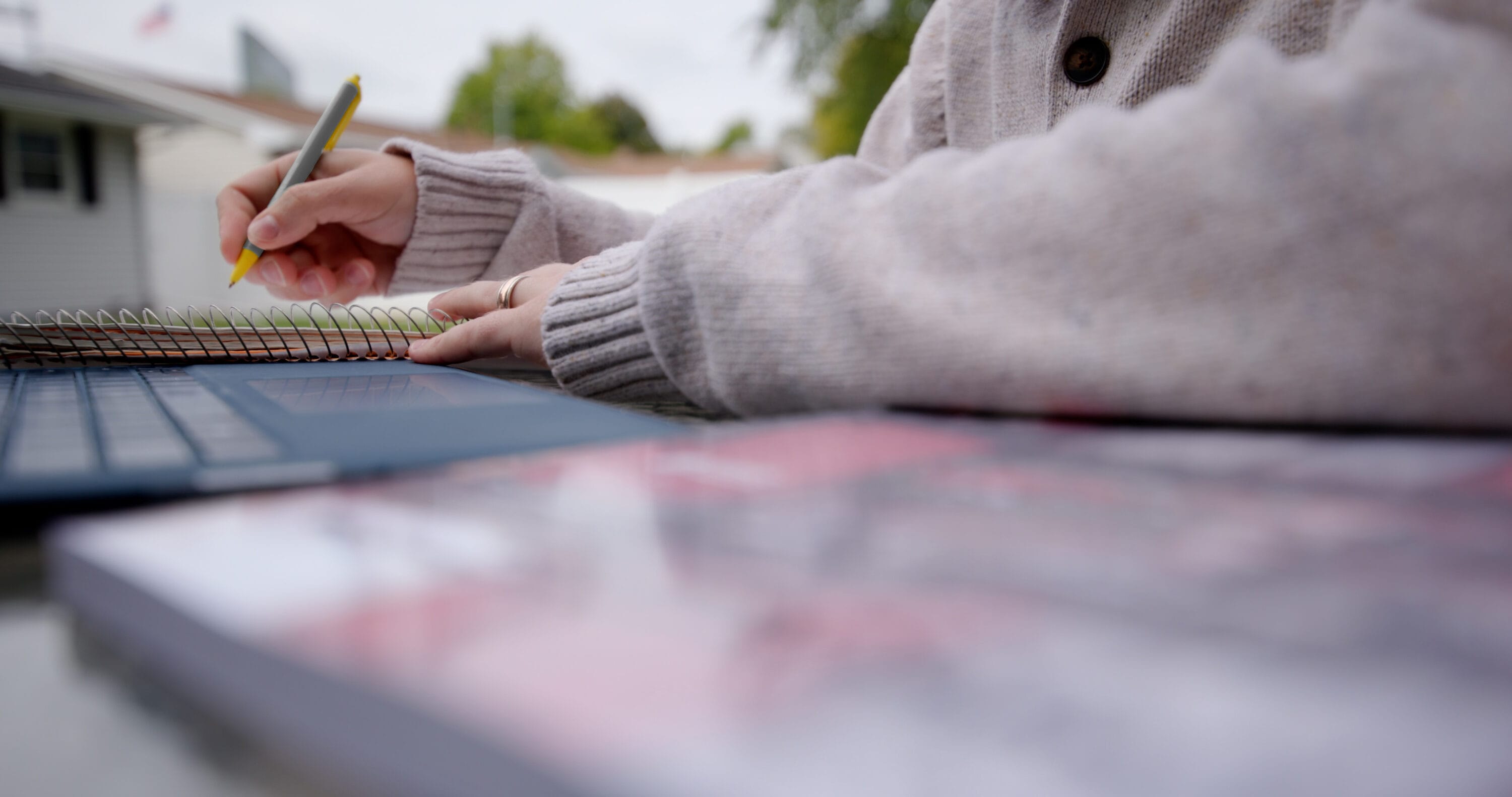 An image of John Gloeckler's hands as he writes on a notebook.