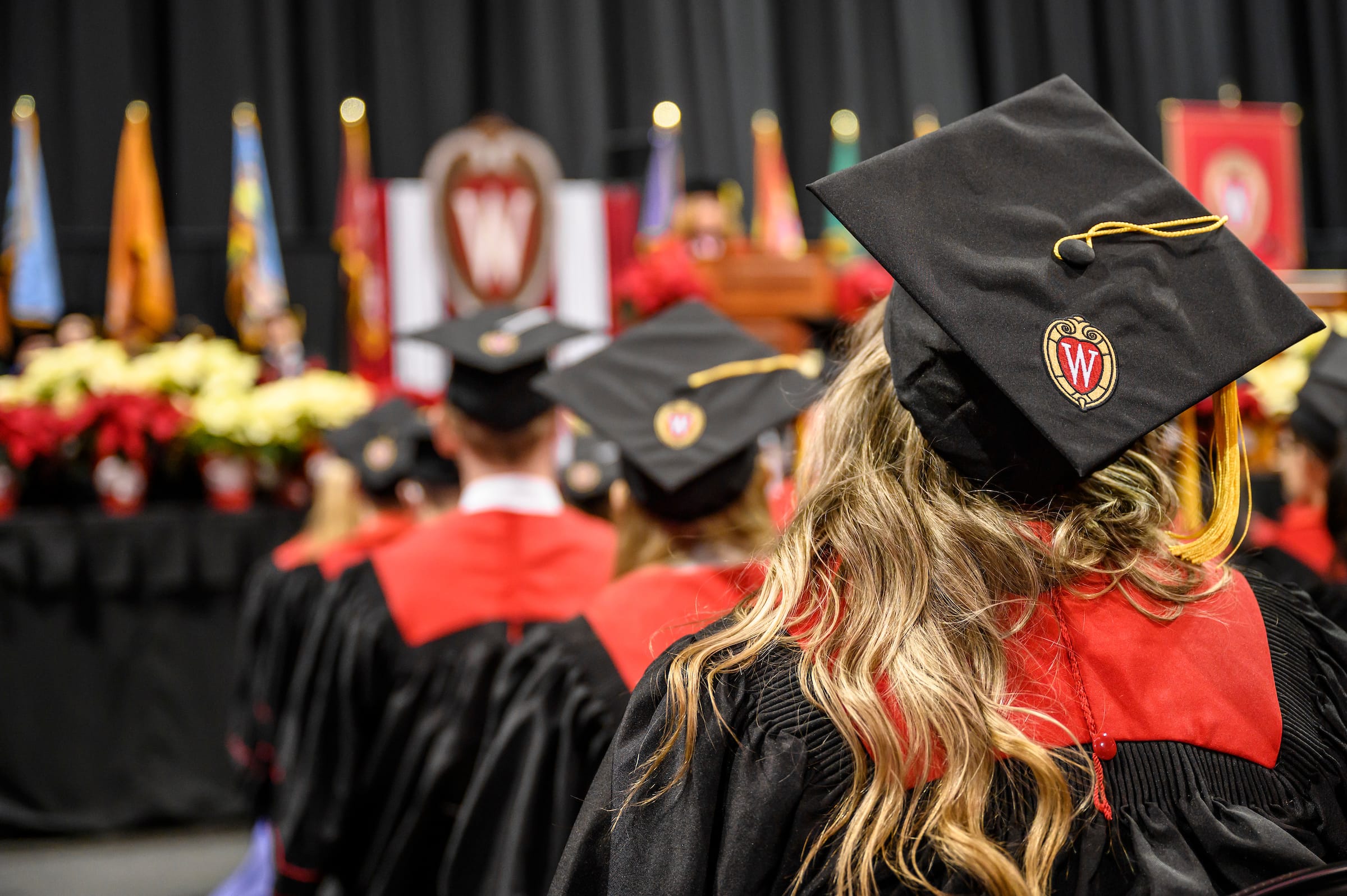 An image of UW-Madison graduates and their graduation caps.