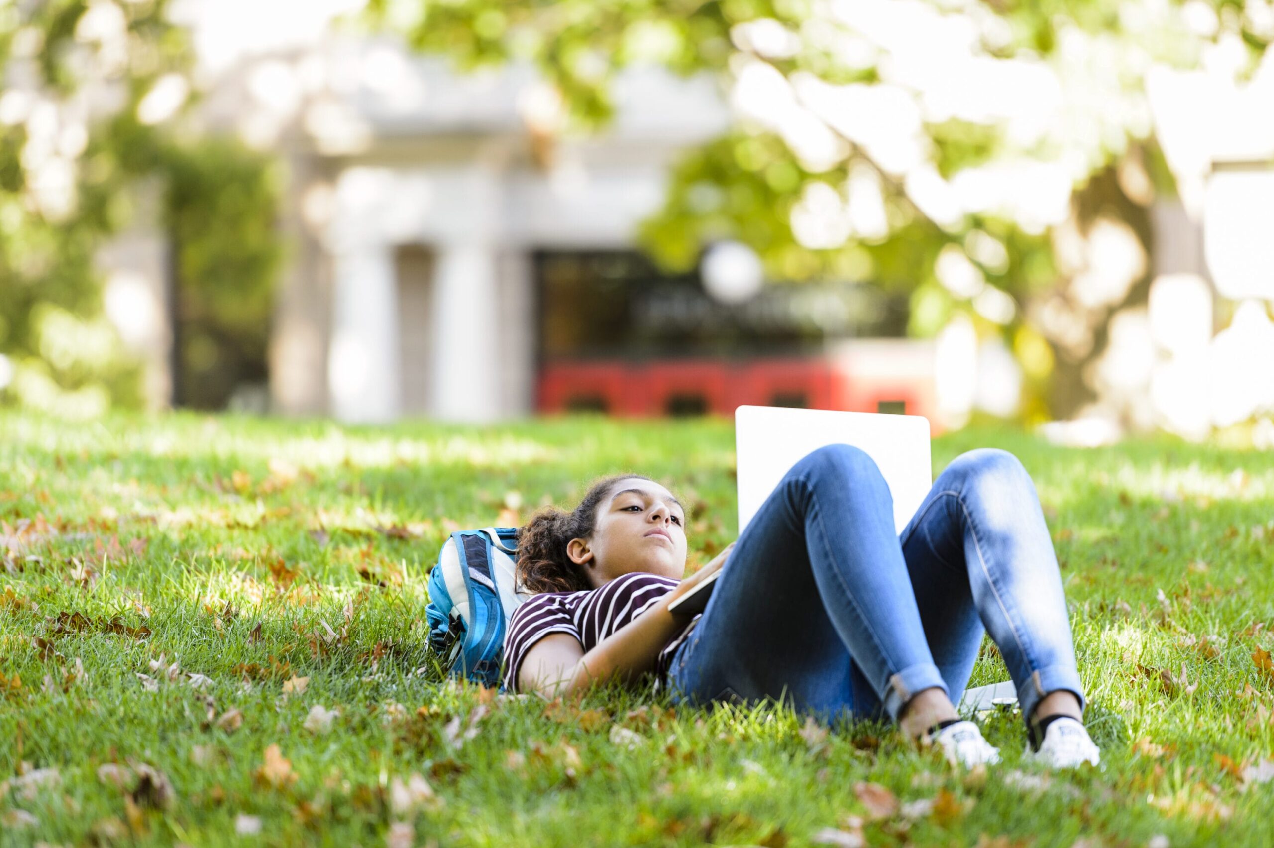 A student lying on the grass on Bascom Hill.