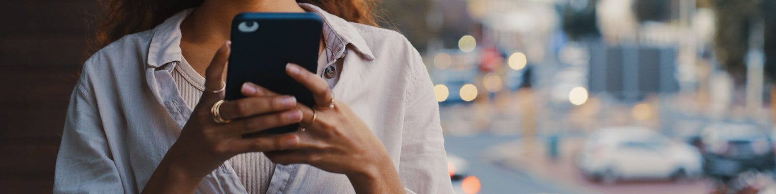 A pair of woman's hand texting on her phone.