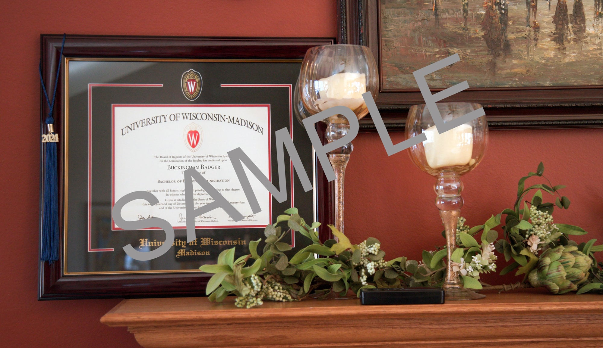 University of Wisconsin-Madison diploma in a wooden frame with tassel, next to candle holders.