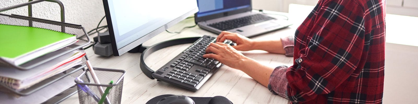 A pair of hands typing on a keyboard