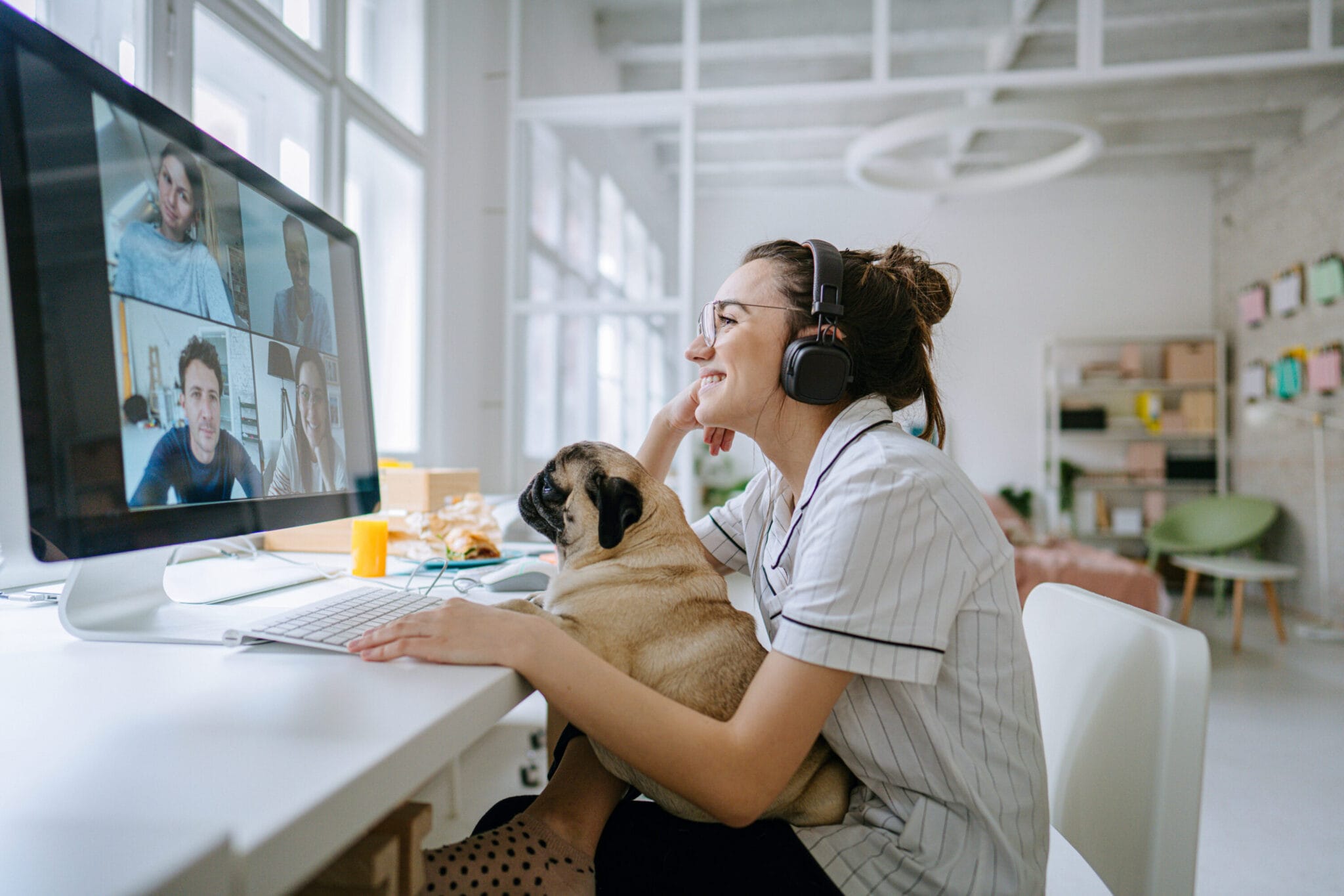 A woman with her dog on her lap attending a videocall.