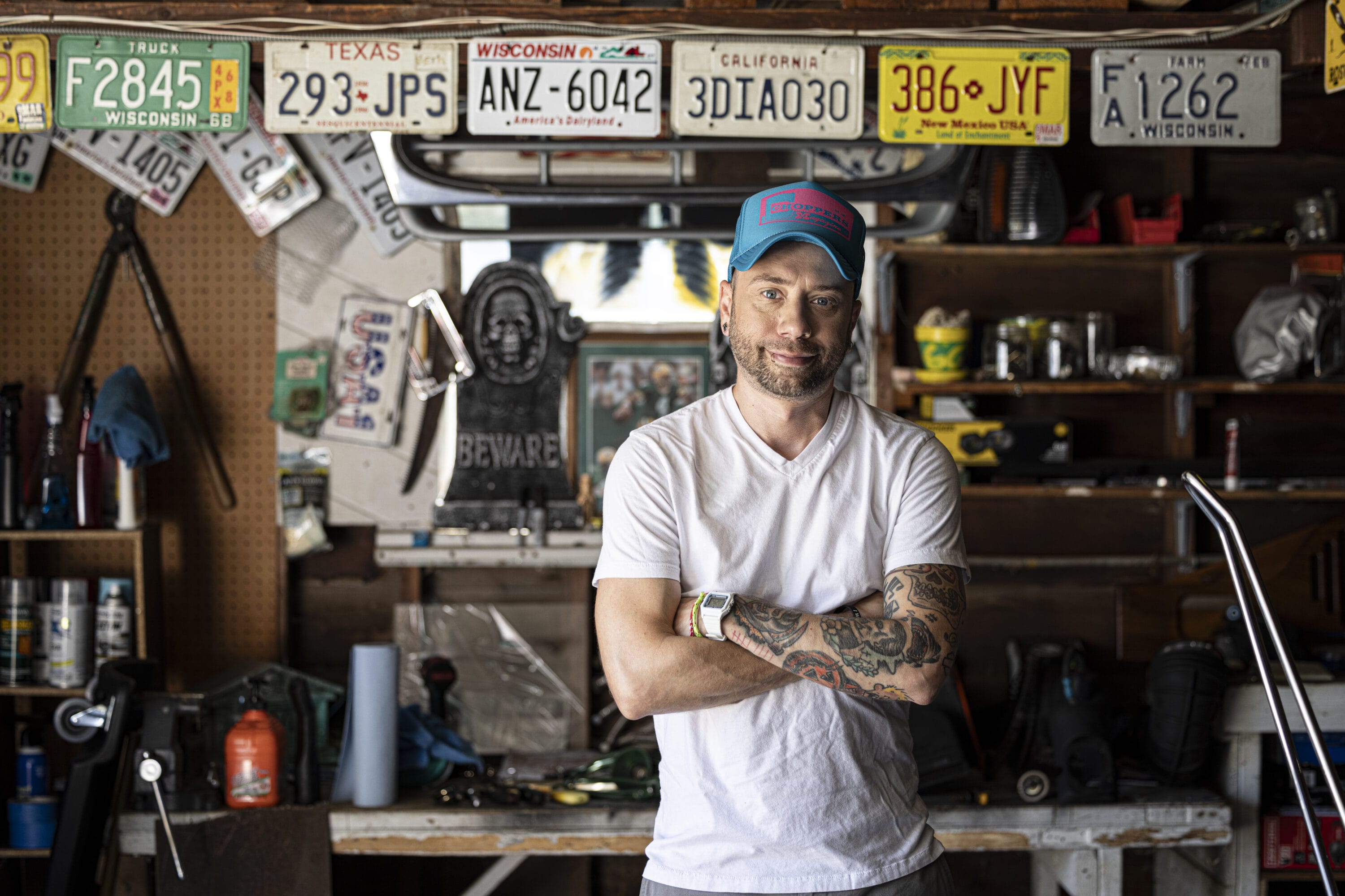 Joey Nicgorski smiling for the camera with his arms crossed in his garage.