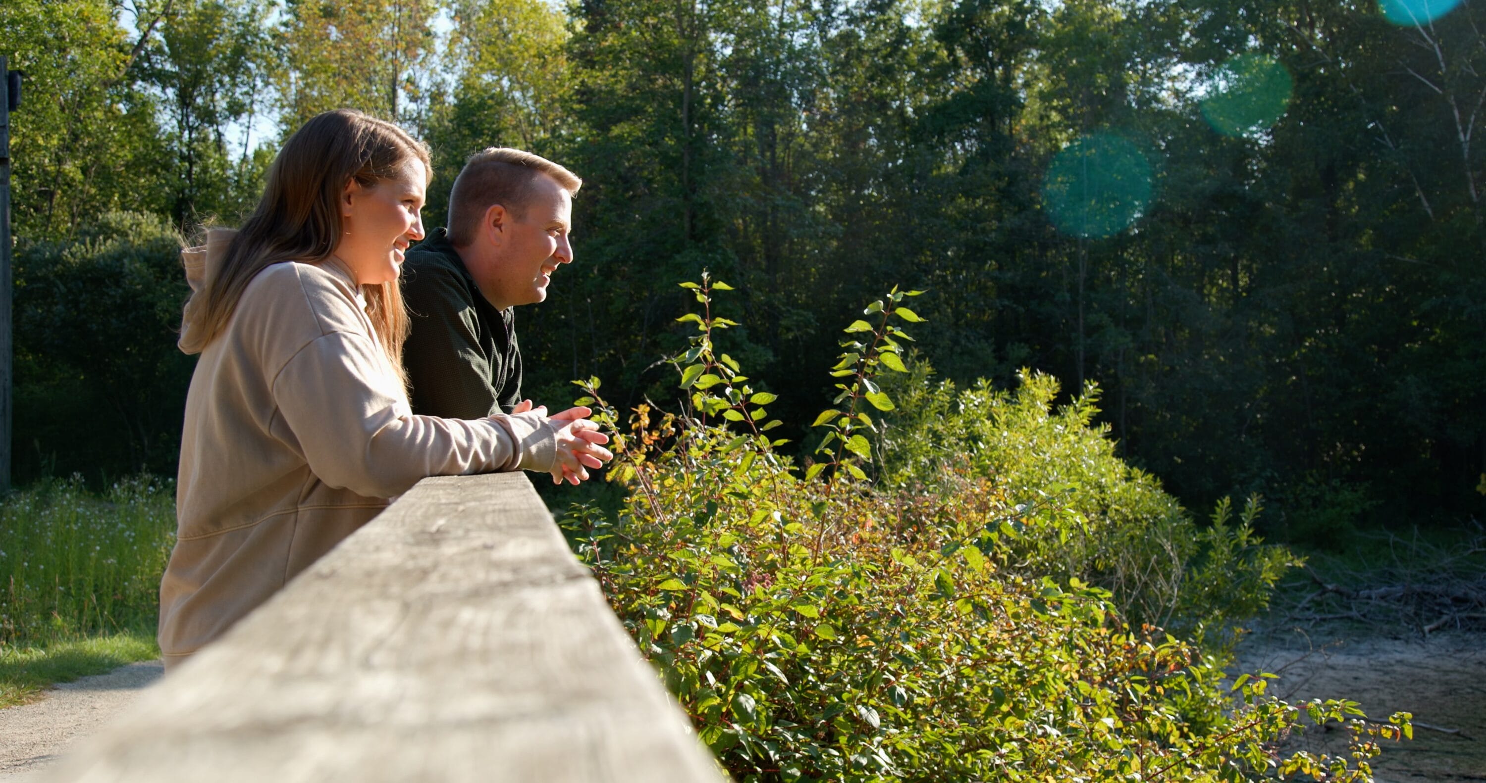 John Gloeckler next to a woman looking at the woods in front of them.