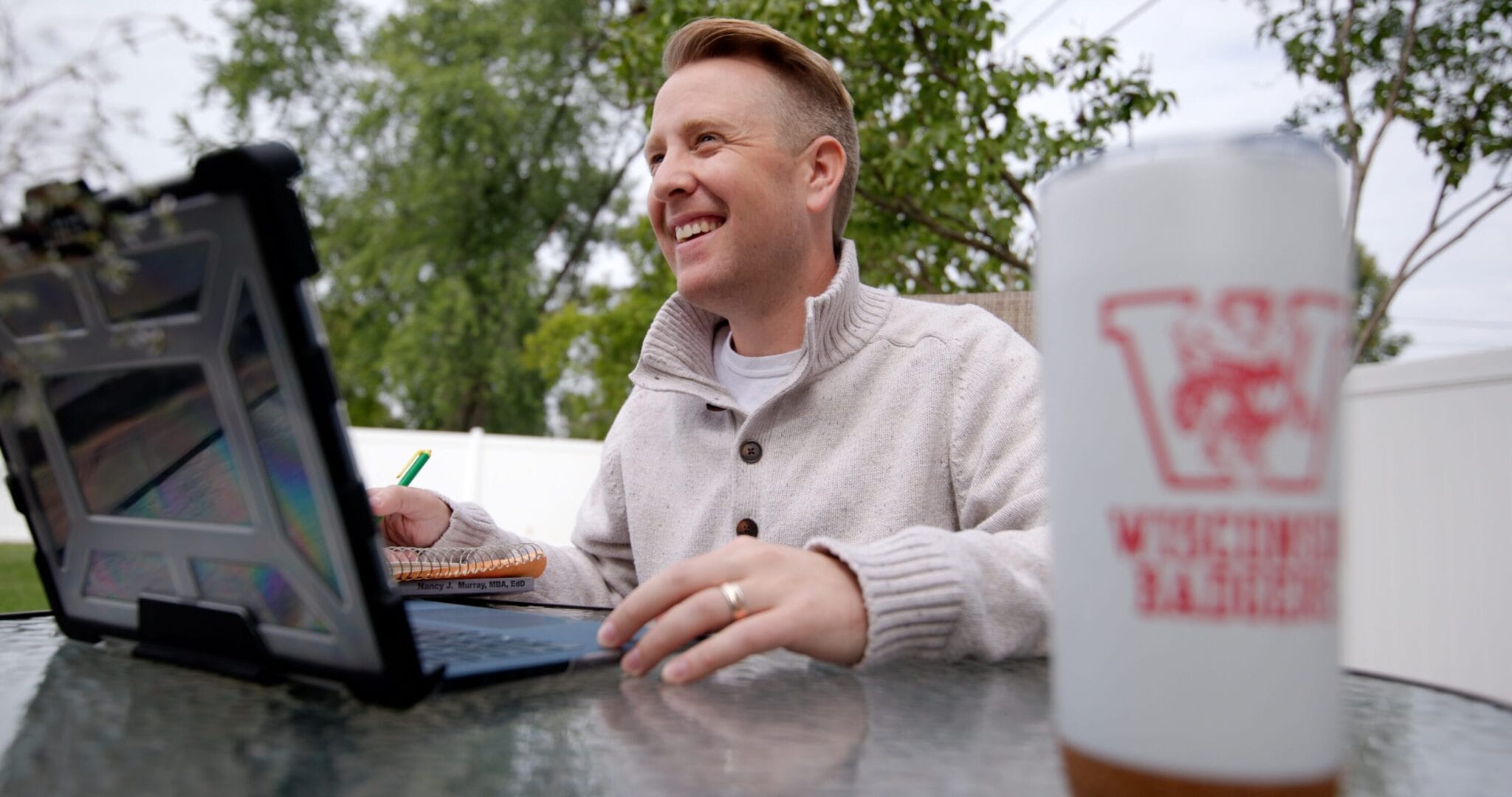 John Gloeckler working in his yard on his laptop.