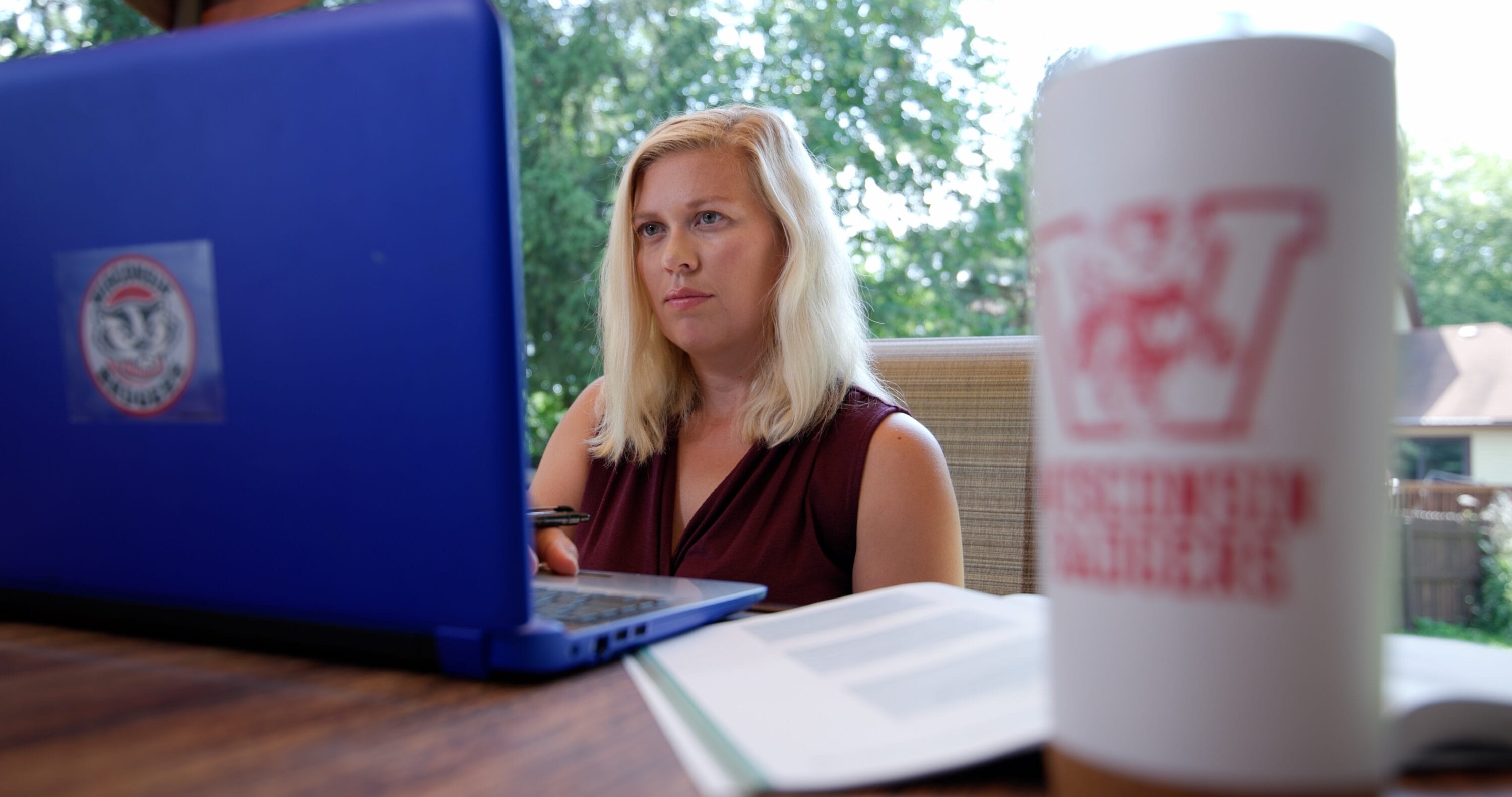 Kristy Jorgensen working on her laptop in her yard.