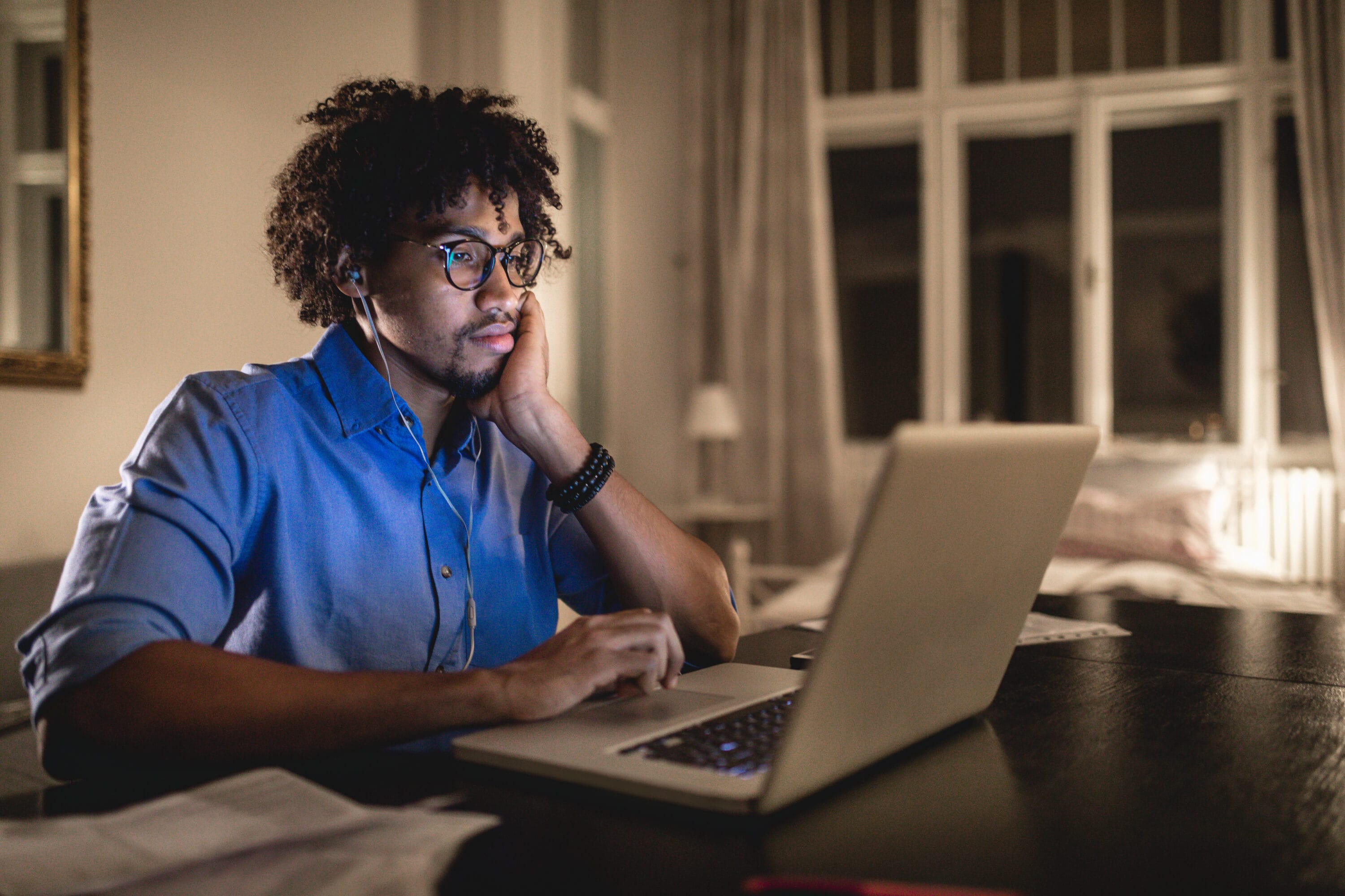 A man working on his laptop at nighttime.