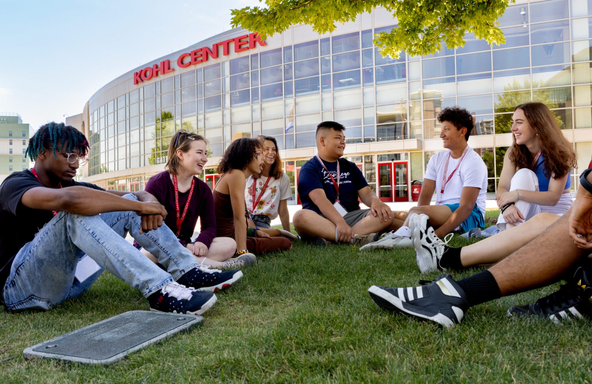 A group of precollege students sitting outside the Kohl Center.