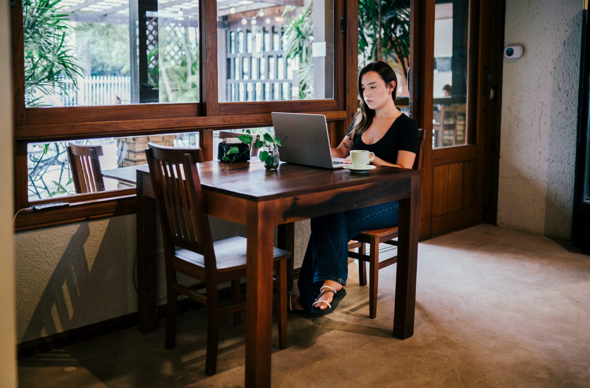 A woman working on her laptop from a coffee shop.