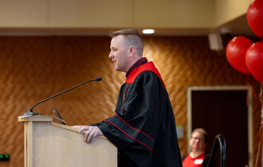 John speaking at the podium