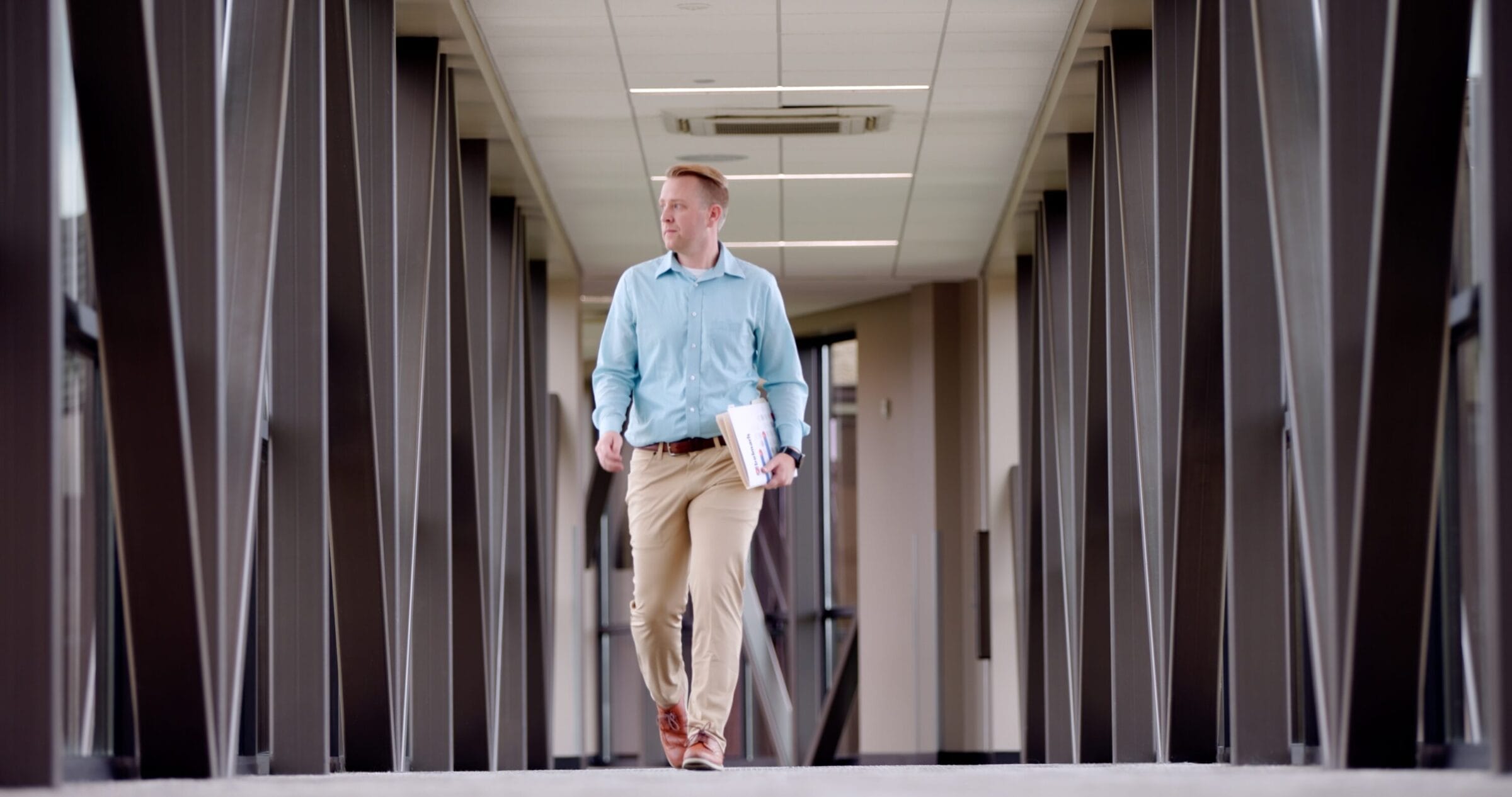 John Goeckler walking down a hall