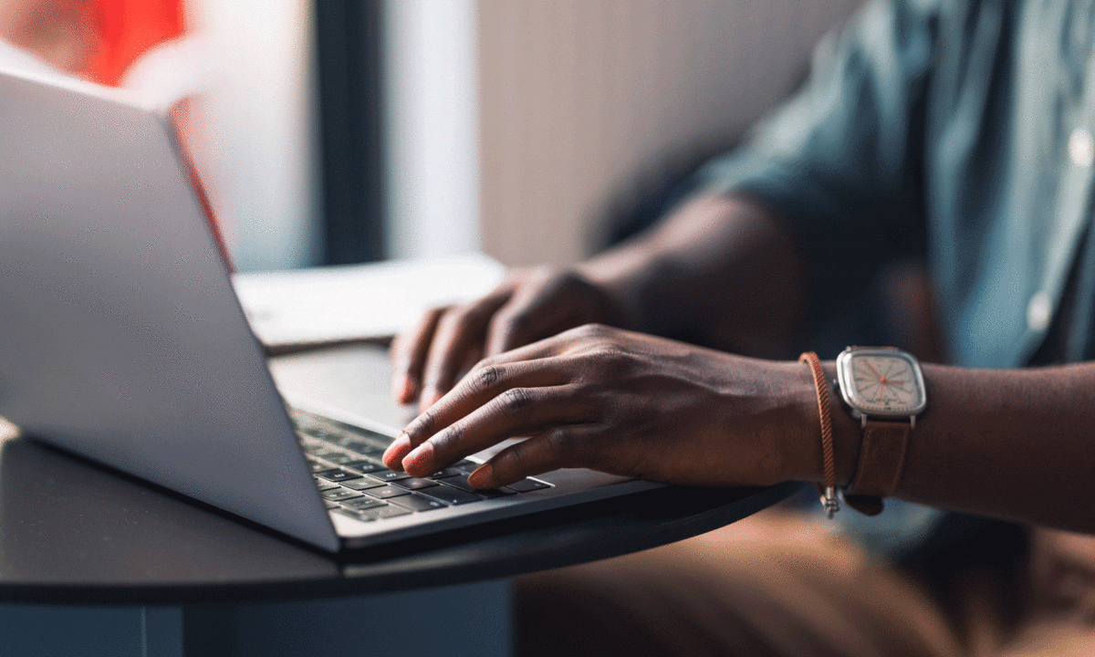 person's hands typing on a laptop