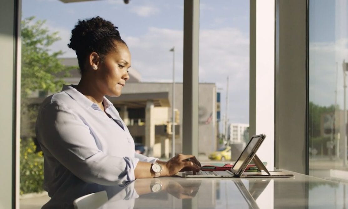 woman on her tablet in front of a window