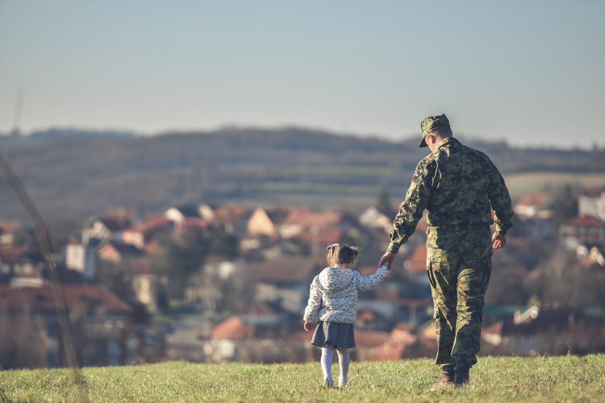 A soldier walking with his daughter